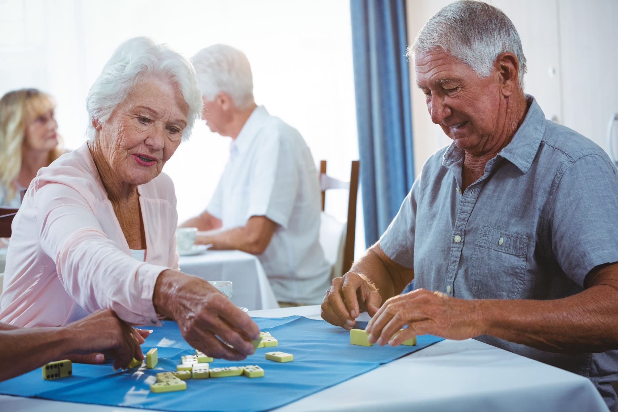 Senior persons enjoy playing domino